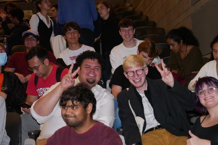 A group of sitting students smile